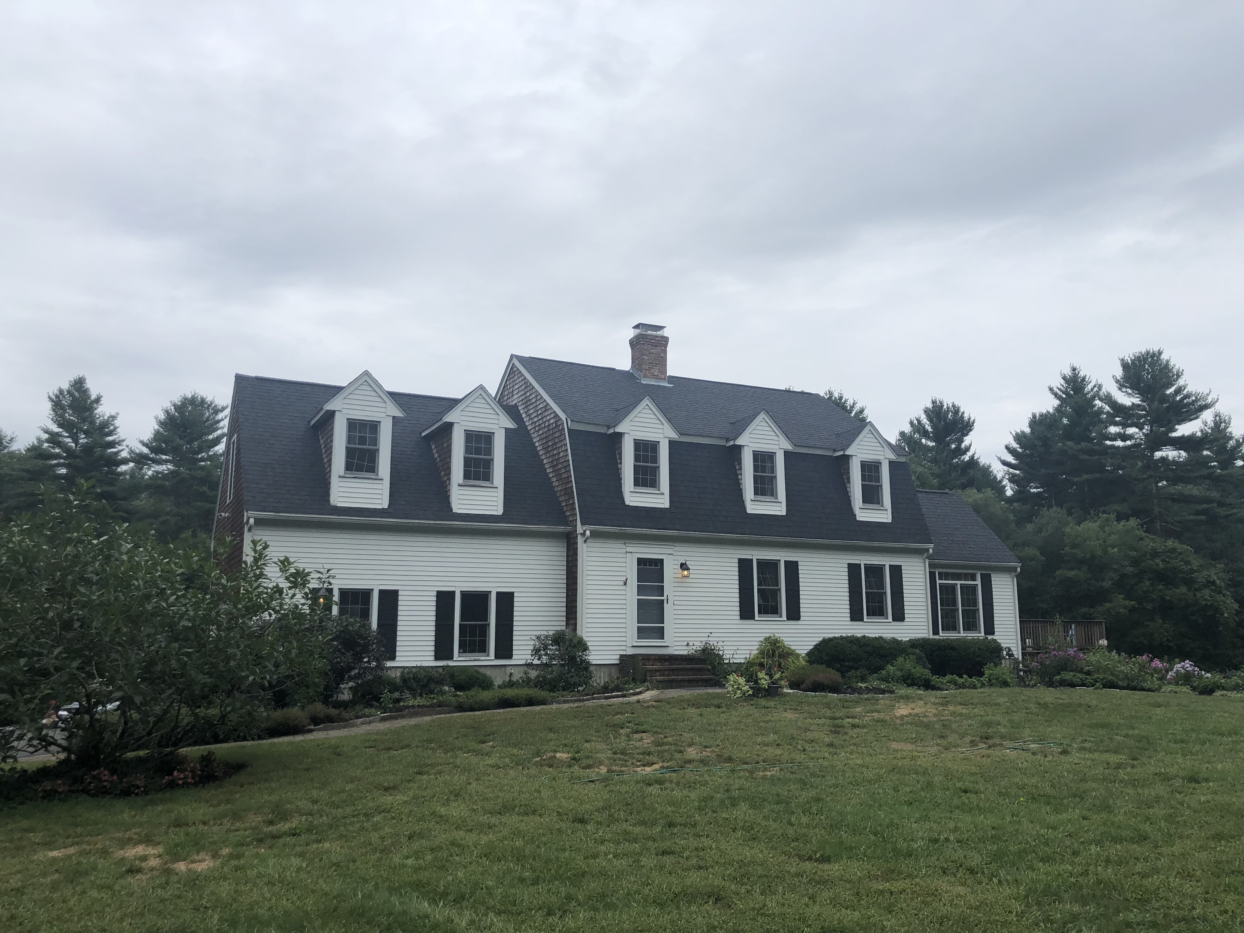 Colonial home exterior in Plympton, MA with a new shingle roof installed by Storm King Roofing