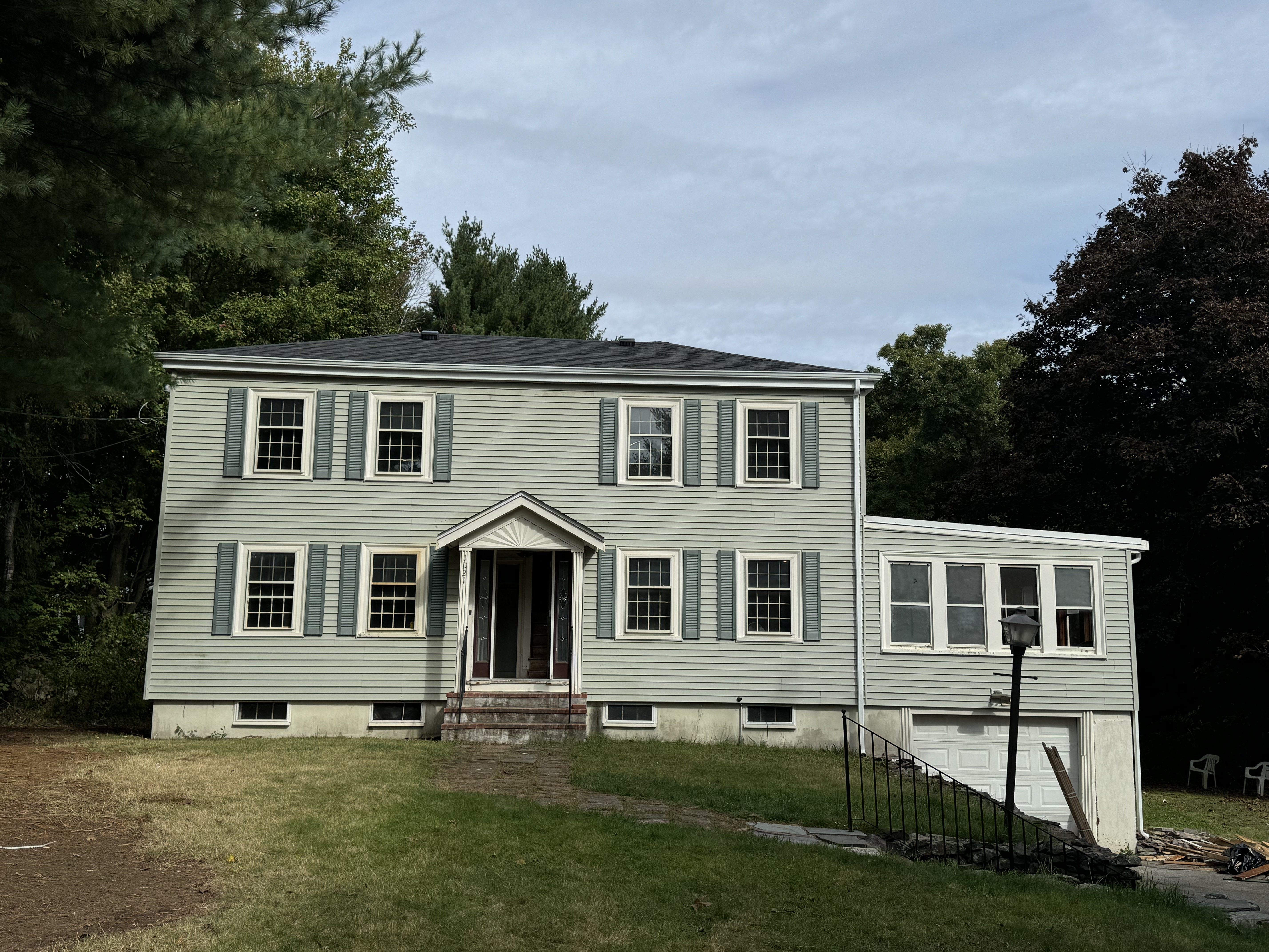 Completed light-green vinyl siding installation by Storm King Roofing on a colonial home in Brockton, MA